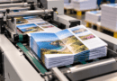 Folded travel brochures stacked on a print finishing machine
