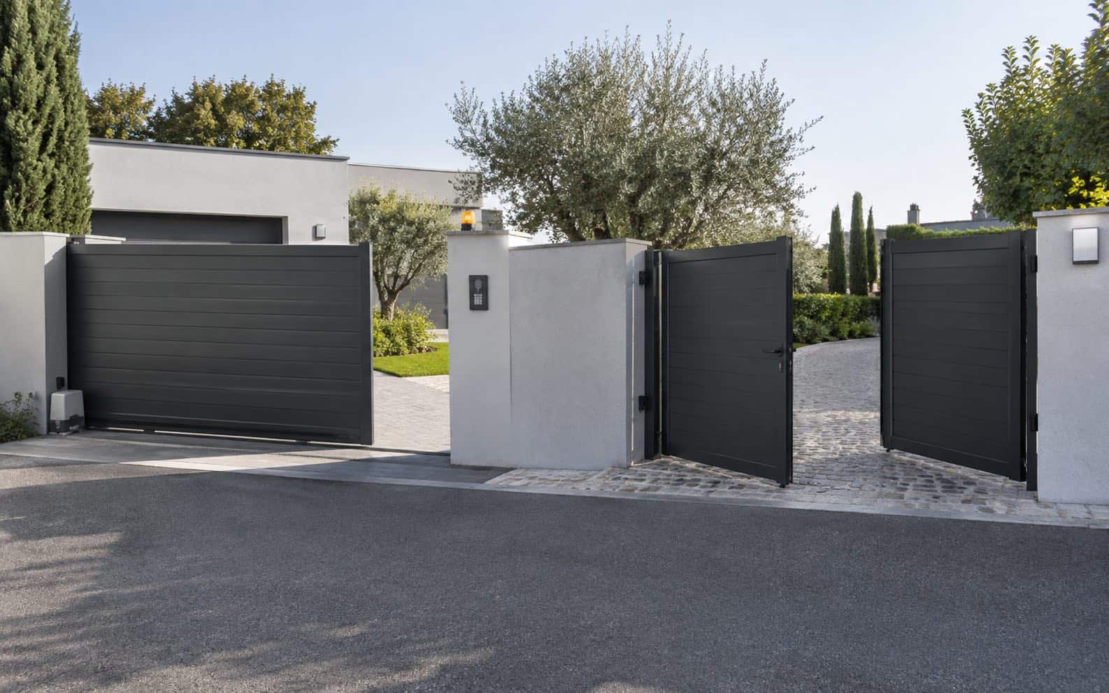 Grey sliding driveway gate beside a matching pair of open swing gates